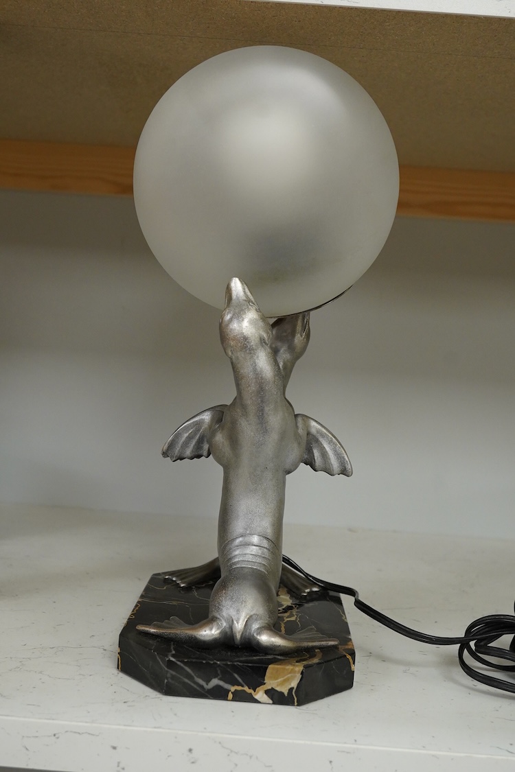 After Louis Carvin (French, 1875-1951) a twin seal lamp with circular frosted glass shade, 34cm high